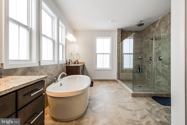 bathroom featuring vanity, tile walls, and separate shower and tub