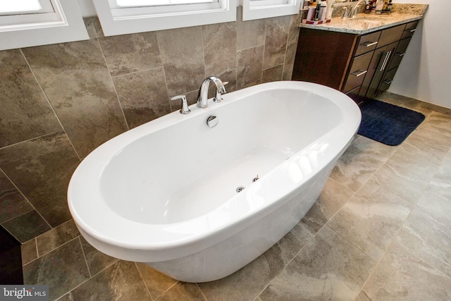 bathroom featuring vanity and a tub to relax in