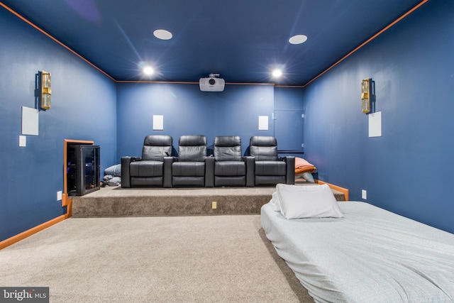 carpeted home theater room featuring crown molding and beverage cooler