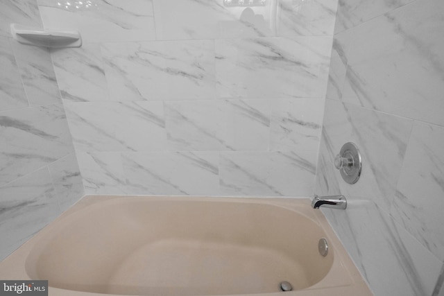 bathroom featuring tiled shower / bath