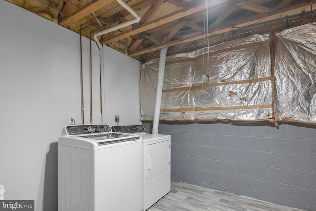 laundry area with light hardwood / wood-style floors and separate washer and dryer