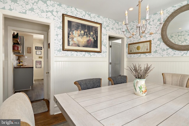 dining space with dark hardwood / wood-style floors and a chandelier