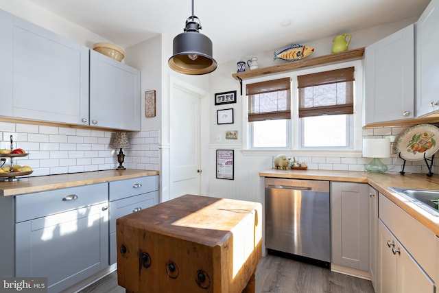 kitchen with white cabinetry, butcher block counters, dishwasher, and hanging light fixtures