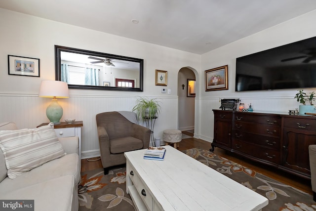 living room featuring dark wood-type flooring and ceiling fan