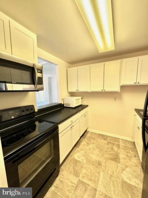 kitchen with white cabinetry and black electric range