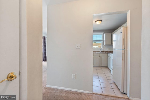 hallway featuring sink and light tile patterned floors