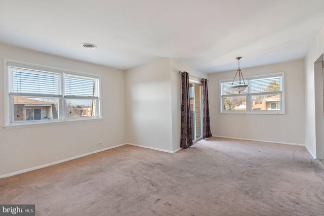 carpeted spare room featuring a healthy amount of sunlight