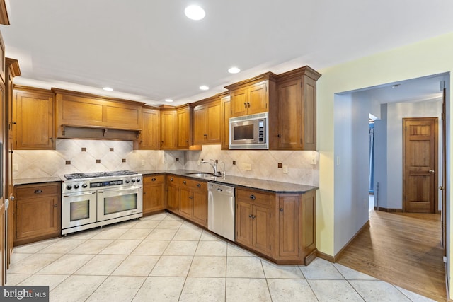 kitchen featuring sink, light tile patterned flooring, decorative backsplash, and stainless steel appliances