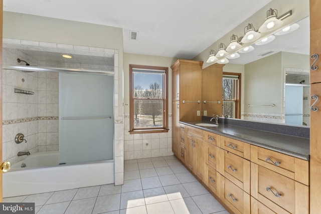 bathroom featuring vanity, tile patterned flooring, plenty of natural light, and enclosed tub / shower combo