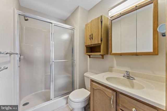 bathroom with an enclosed shower, vanity, and toilet