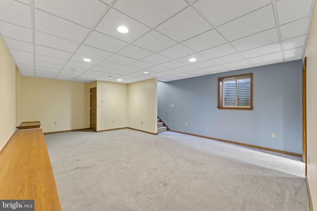 basement featuring light colored carpet and a drop ceiling