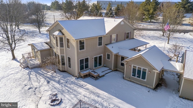 view of snow covered back of property