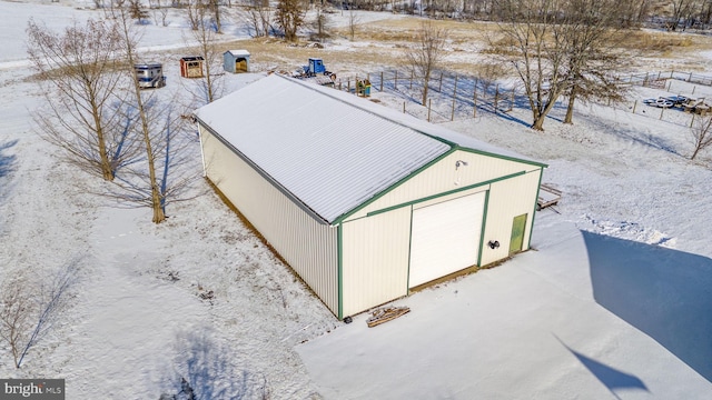 snow covered structure with a garage