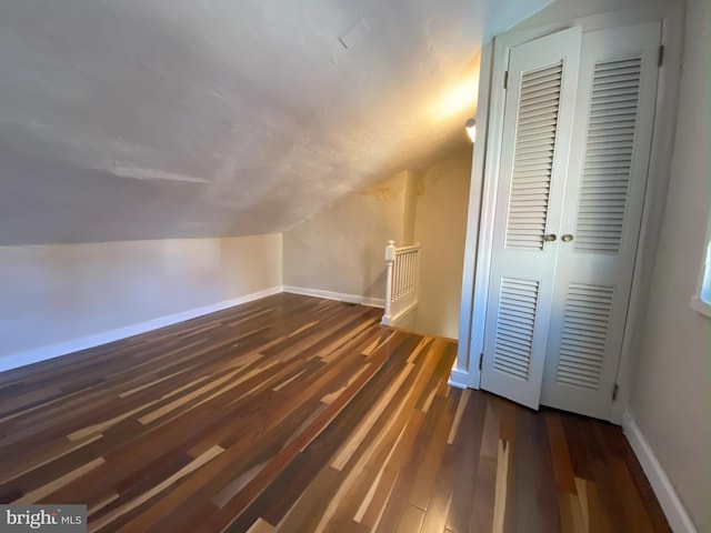 bonus room featuring vaulted ceiling and dark hardwood / wood-style flooring