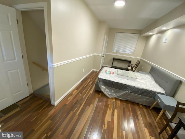 bedroom with dark wood-type flooring