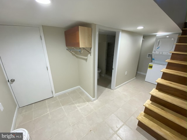 basement featuring stacked washer / drying machine