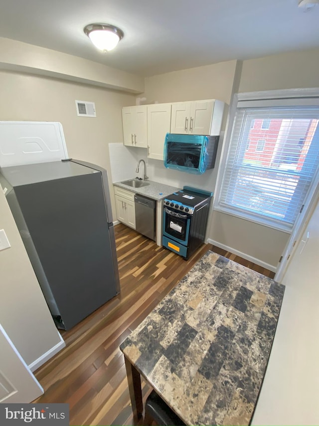 kitchen featuring white cabinets, appliances with stainless steel finishes, sink, and dark hardwood / wood-style flooring