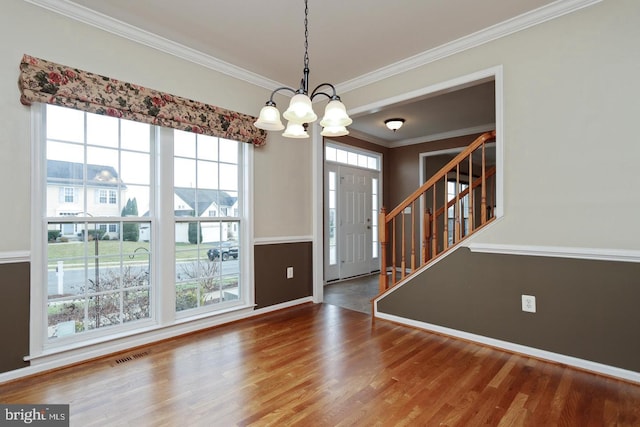 foyer entrance featuring hardwood / wood-style flooring, a chandelier, and ornamental molding