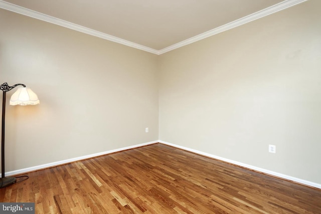 empty room with ornamental molding and hardwood / wood-style floors