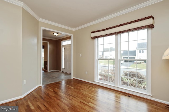 unfurnished room featuring plenty of natural light, wood-type flooring, and ornamental molding