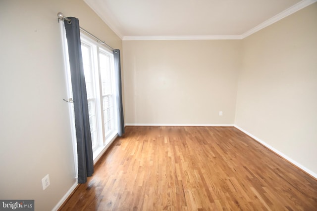 empty room featuring light wood-type flooring and ornamental molding