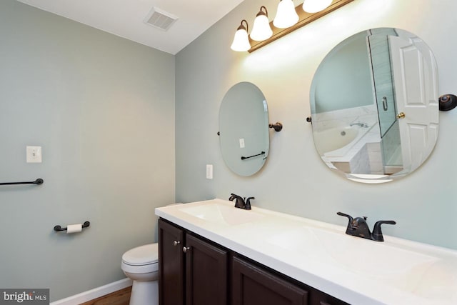 bathroom with wood-type flooring, toilet, a tub to relax in, and vanity