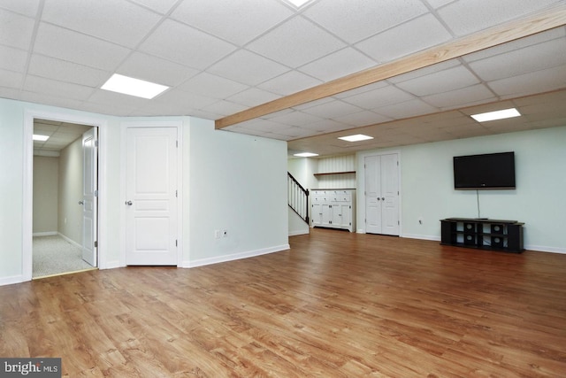 basement with hardwood / wood-style floors and a paneled ceiling