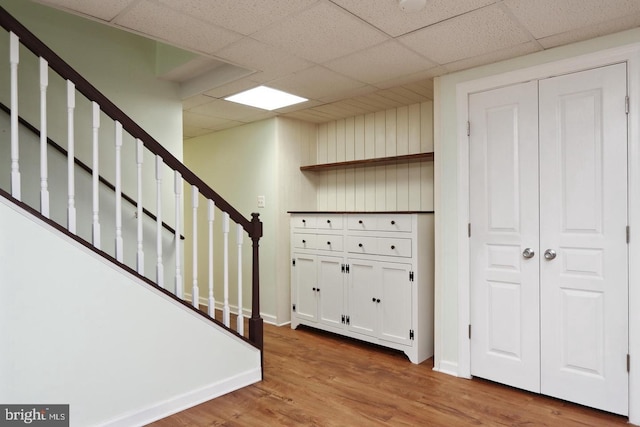 interior space with a paneled ceiling and hardwood / wood-style floors