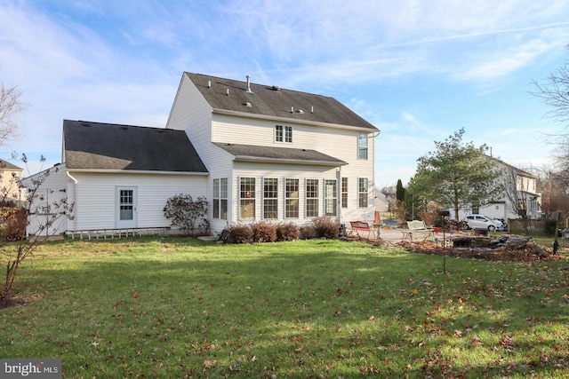 rear view of house featuring a patio area and a lawn