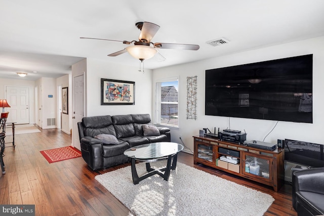 living room featuring ceiling fan and dark hardwood / wood-style flooring