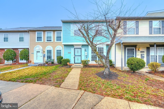 townhome / multi-family property featuring a front lawn