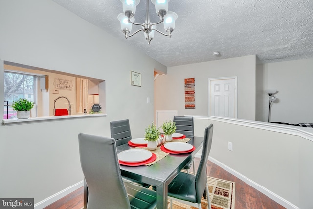 dining room with hardwood / wood-style flooring, a textured ceiling, and a chandelier