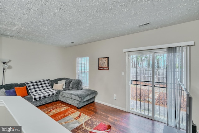 living room with hardwood / wood-style floors and a textured ceiling