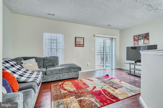 living room featuring dark hardwood / wood-style flooring and a textured ceiling