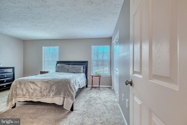 carpeted bedroom featuring multiple windows and a textured ceiling