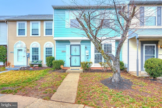 townhome / multi-family property featuring a front lawn