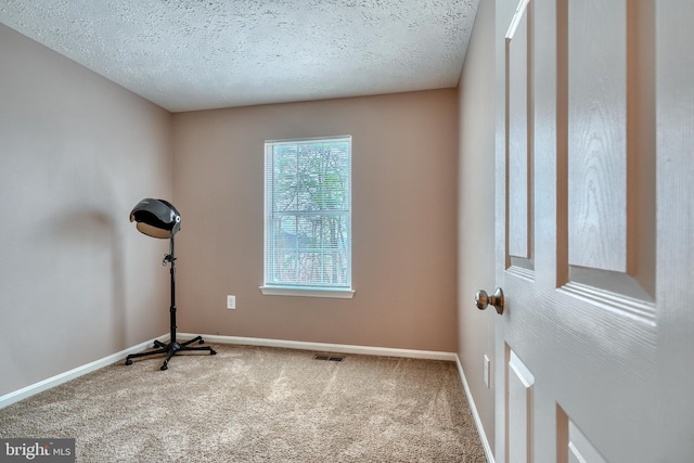 workout room featuring carpet floors and a textured ceiling