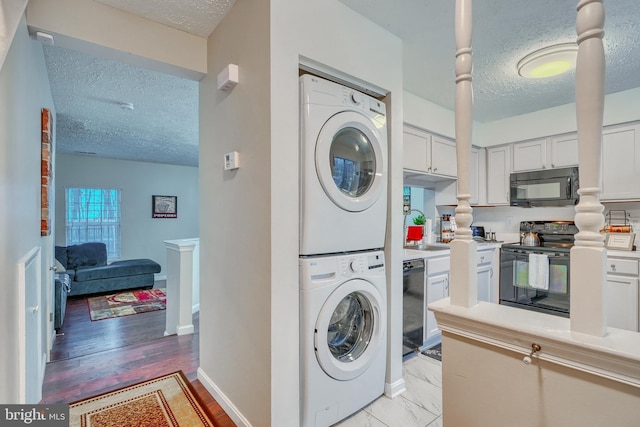 laundry room featuring stacked washer and dryer and a textured ceiling