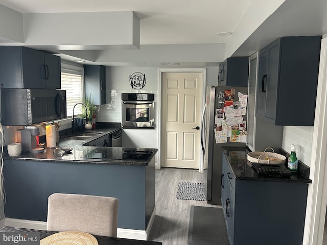 kitchen with sink, decorative backsplash, stainless steel appliances, and kitchen peninsula