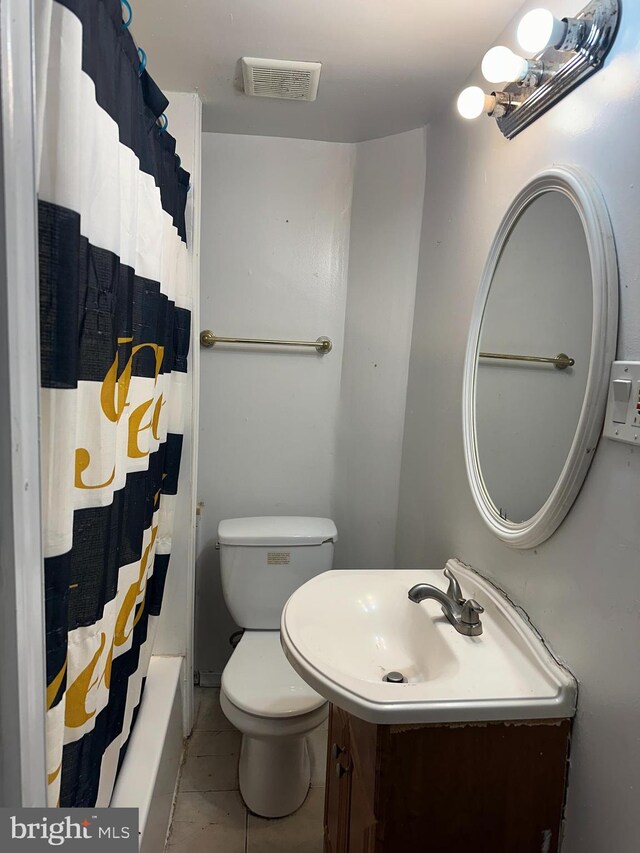 bathroom with tile patterned flooring, vanity, and toilet