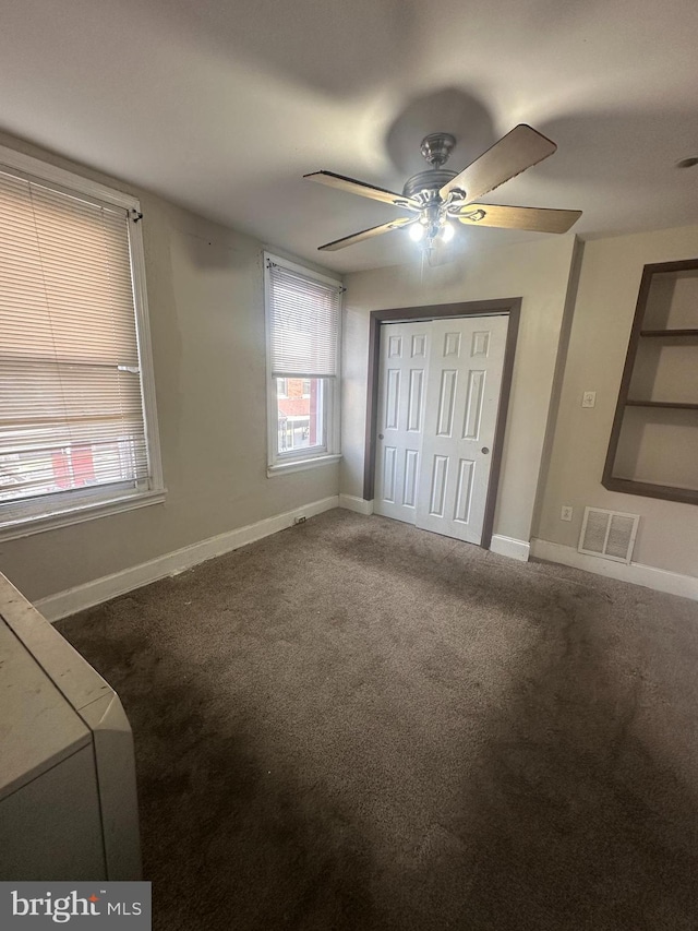 unfurnished bedroom featuring ceiling fan, a closet, and carpet