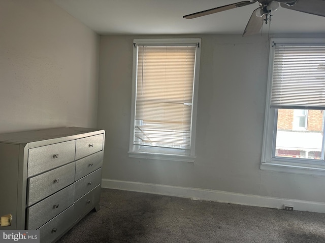 interior space featuring dark colored carpet and ceiling fan