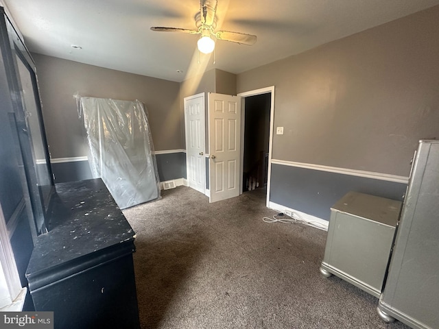 unfurnished bedroom featuring dark carpet and ceiling fan