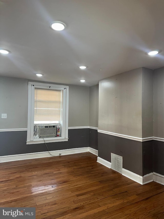 empty room with cooling unit and hardwood / wood-style flooring