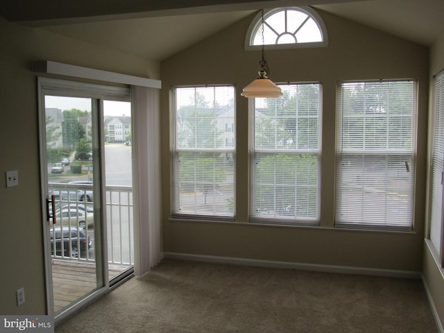 unfurnished dining area featuring vaulted ceiling and carpet flooring