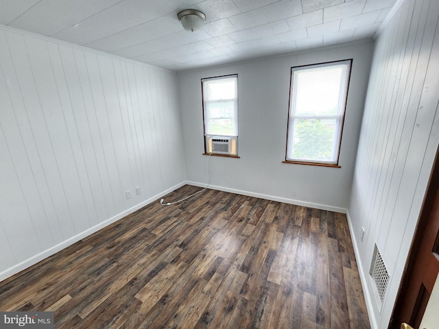 empty room featuring cooling unit, dark hardwood / wood-style floors, and wood walls