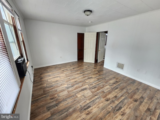 spare room with wood-type flooring and an AC wall unit