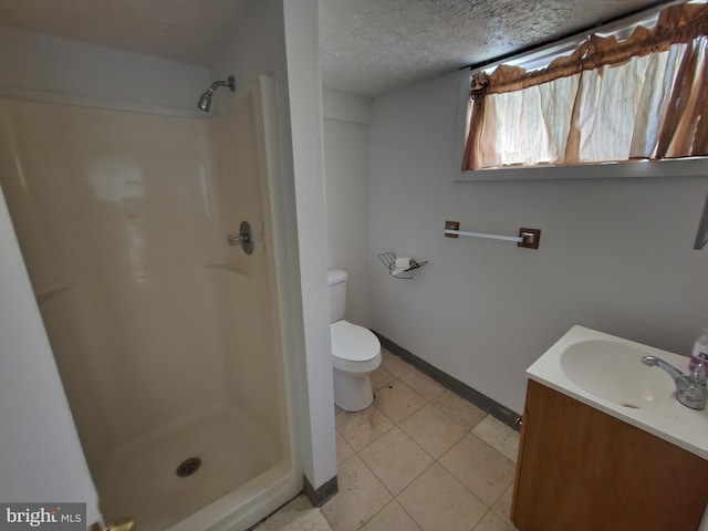 bathroom featuring toilet, vanity, a shower, and a textured ceiling