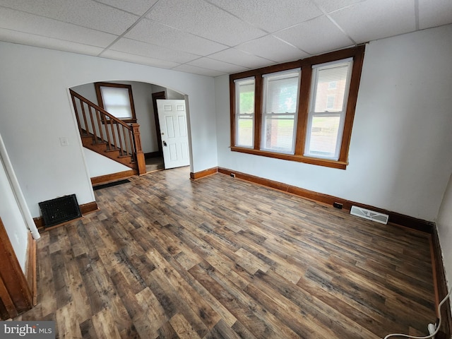 unfurnished room with a drop ceiling and dark hardwood / wood-style floors