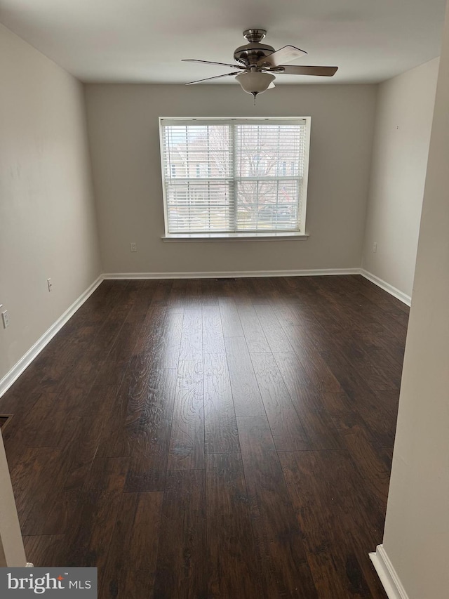 empty room with ceiling fan and dark hardwood / wood-style floors